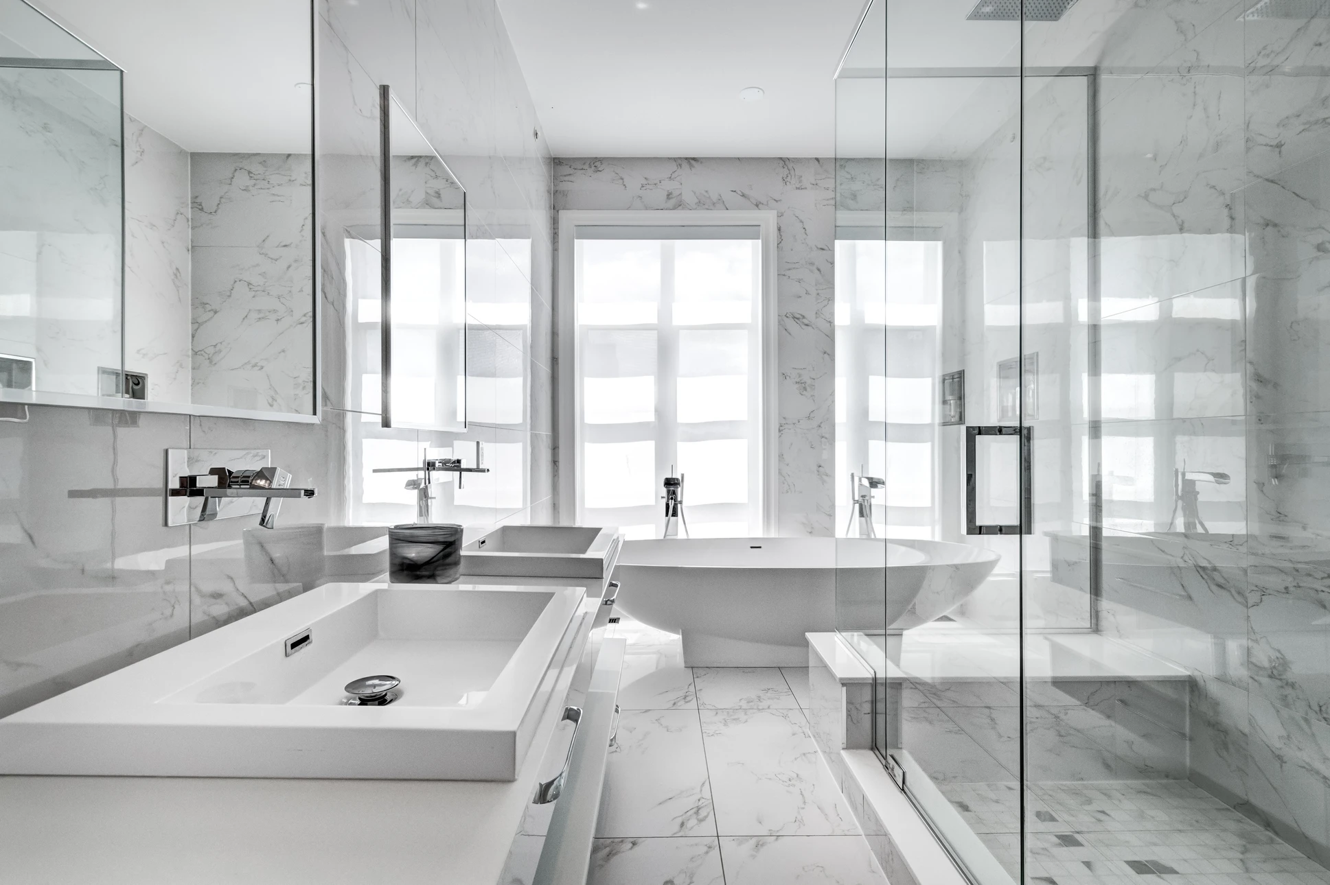 Salle de bain moderne luxueuse avec baignoire îlot centrale et douche à l'italienne séparée par cloison vitrée