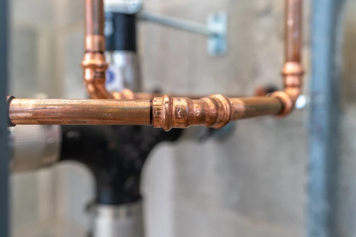 Scène extérieure montrant un compteur de gaz résidentiel installé contre un mur en bardage bois