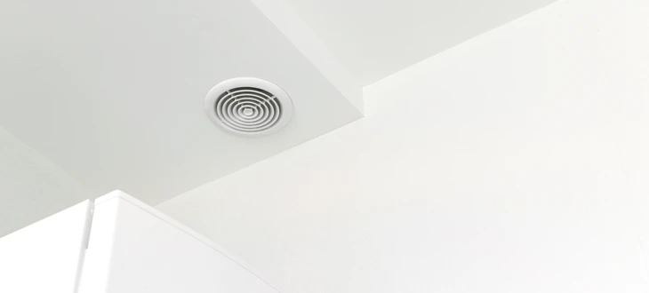 Plafond intérieur moderne avec système de ventilation circulaire concentrique intégré dans structure ondulée métallique