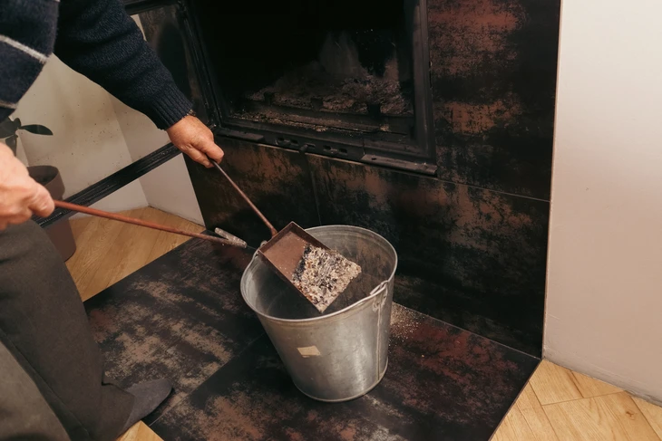 Intérieur chaleureux avec personne en chaussettes rayées se réchauffant les pieds devant un poêle à bois en fonte noir